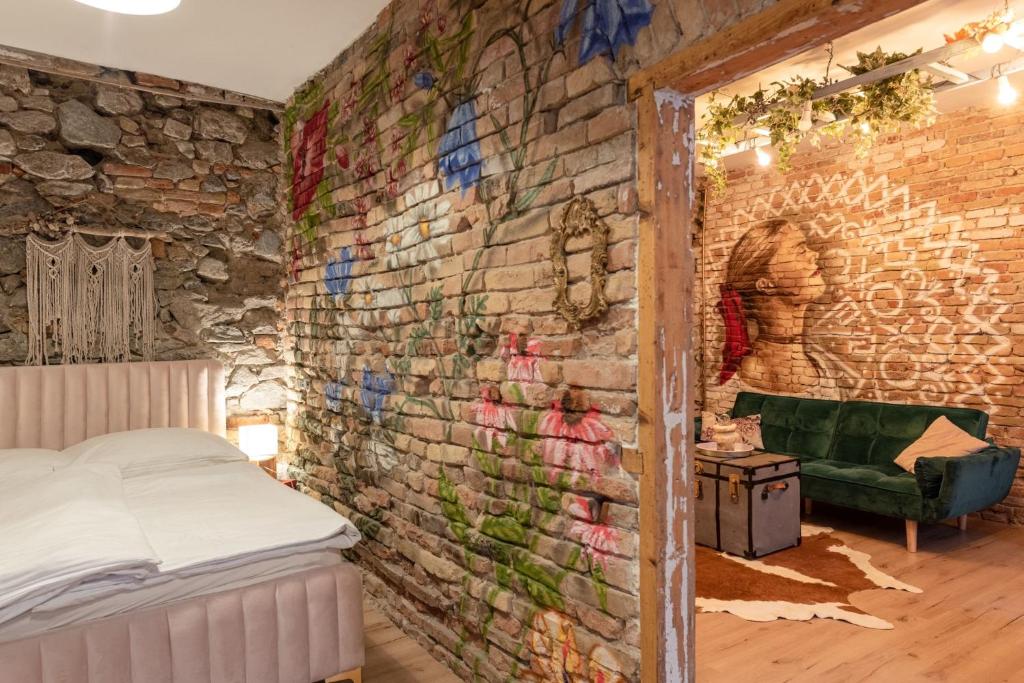 ブラチスラヴァにあるAccommodation at the Folklore Apartmentのレンガの壁の客室で、ベッドが備わります。