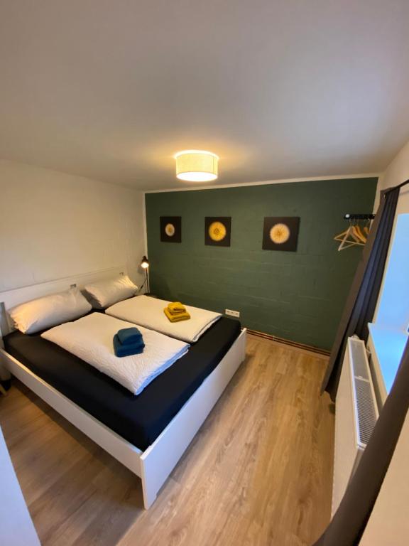 1 dormitorio con cama y pared verde en Ferienwohnung Marschkieker - Kleiner Deichhof, en Hattstedtermarsch