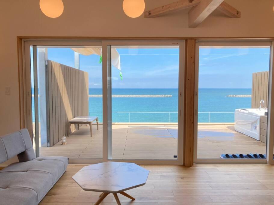 a living room with a couch and a view of the ocean at Beach SPA TSUDA 0 Cero棟 in Sanuki