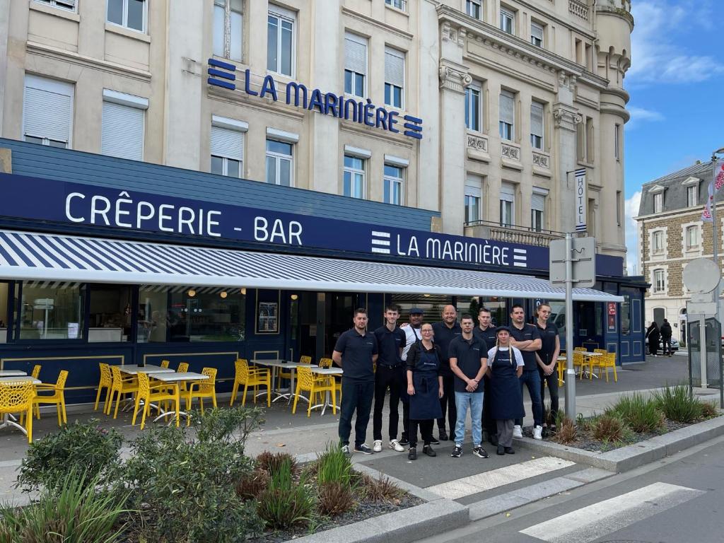 un grupo de personas de pie en frente de un edificio en La Marinière Hôtel Restaurant, en Saint-Malo