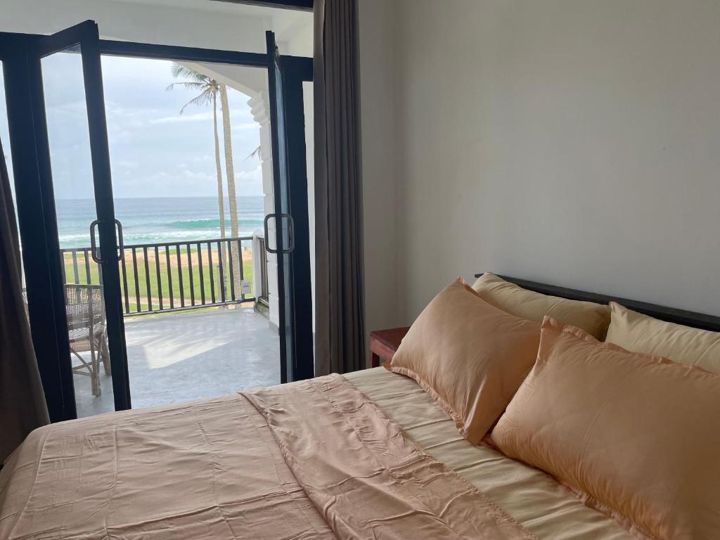 1 dormitorio con 1 cama y vistas al océano en Funky Sol - Sunset Rooftop Bar, Hotel & Restaurant, en Weligama