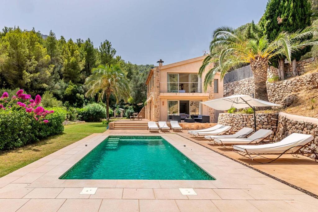 una piscina con tumbonas y una casa en Villa Can Sort, en Sóller