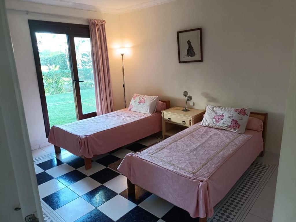 a room with two beds and a table and a window at Villa meublée face à la mer, Golf et Verdure in El Jadida