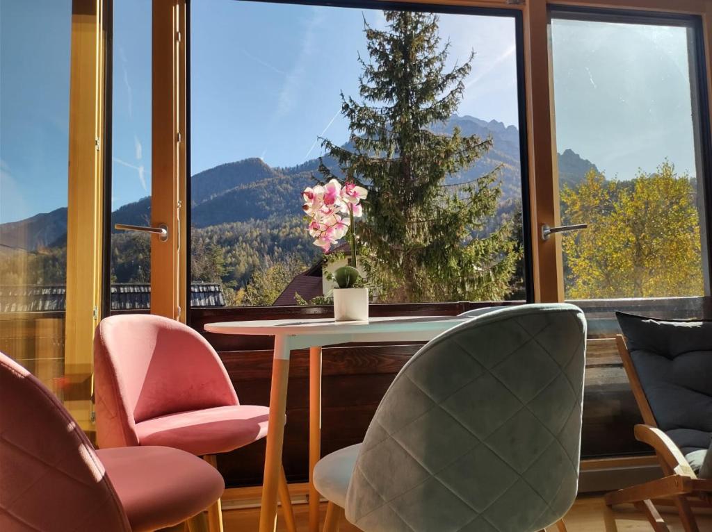 クランスカ・ゴーラにあるAppartement Bella Vistaのテーブルと椅子、大きな窓が備わる客室です。