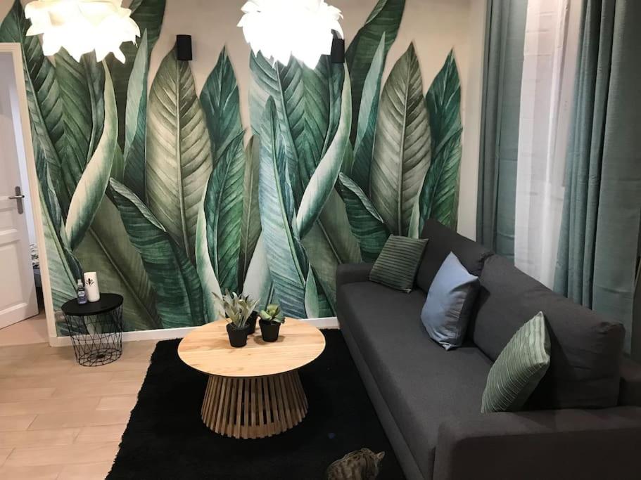 a living room with a couch and a table at La petite maison in Bobigny