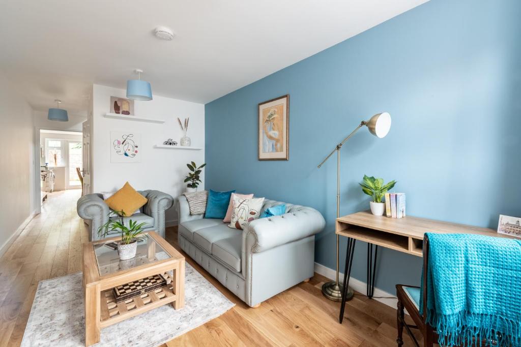 a living room with blue walls and a couch at Dunstan House Luxury Holiday Home with free parking in Oxford