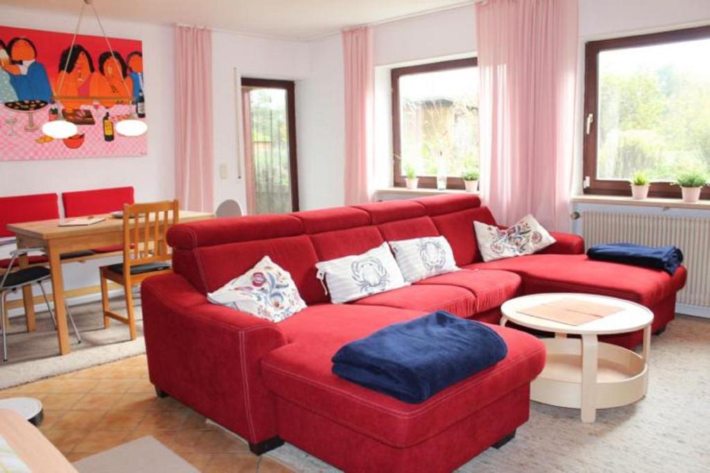 ein Wohnzimmer mit einem roten Sofa und einem Tisch in der Unterkunft Ferienwohnung Nikoll/Simon in Schnaittach