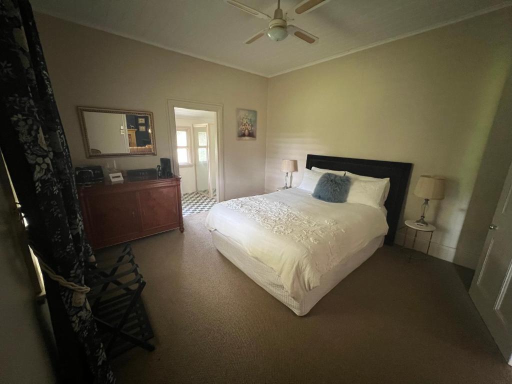 een slaapkamer met een bed en een plafondventilator bij Private suite in an Historic 1865 Homestead in Dubbo