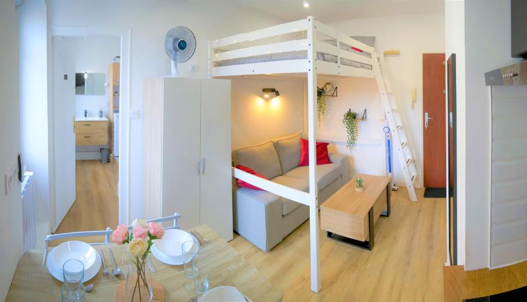 Cette petite chambre comprend des lits superposés et une table. dans l'établissement Studio Northwich centre-ville, à Dole