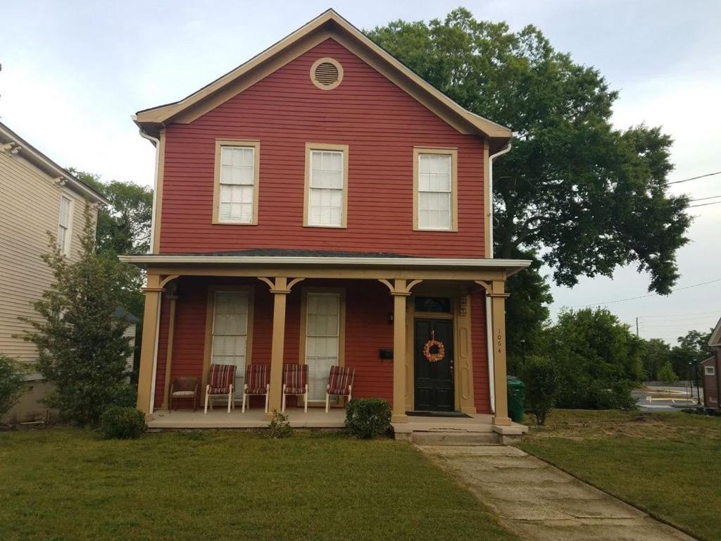 a red house with chairs in the front yard at Suite 4 - Private Apartment Historical Home in Macon