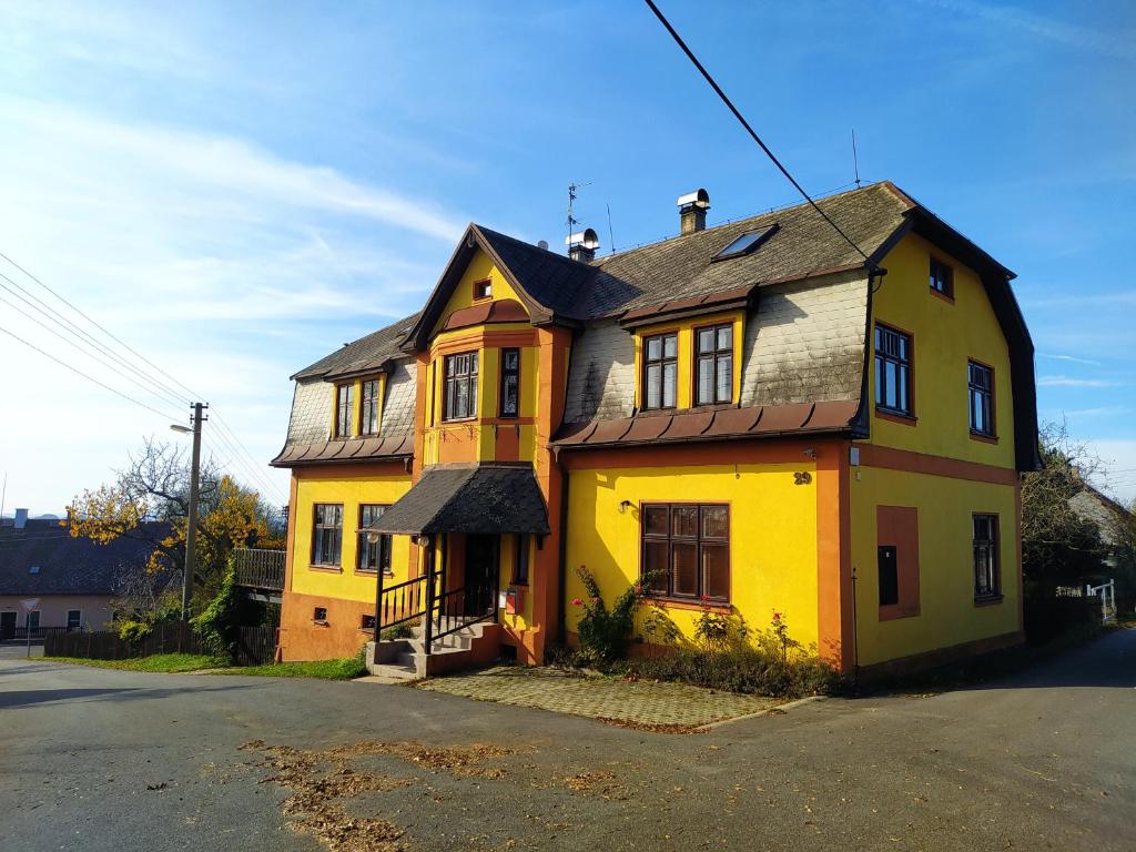 a yellow house sitting on the side of a street at Penzion Hodky in Světlá pod Ještědem