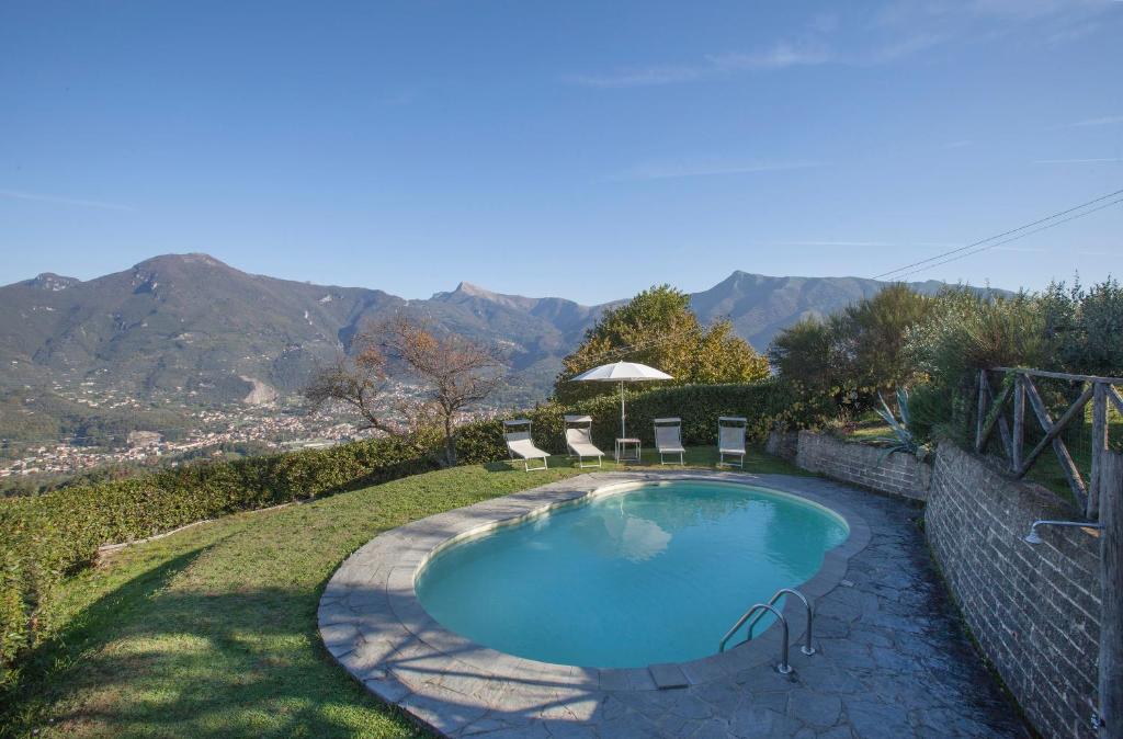 Una piscina en un patio con montañas al fondo. en Villa La Piana, en Mommio