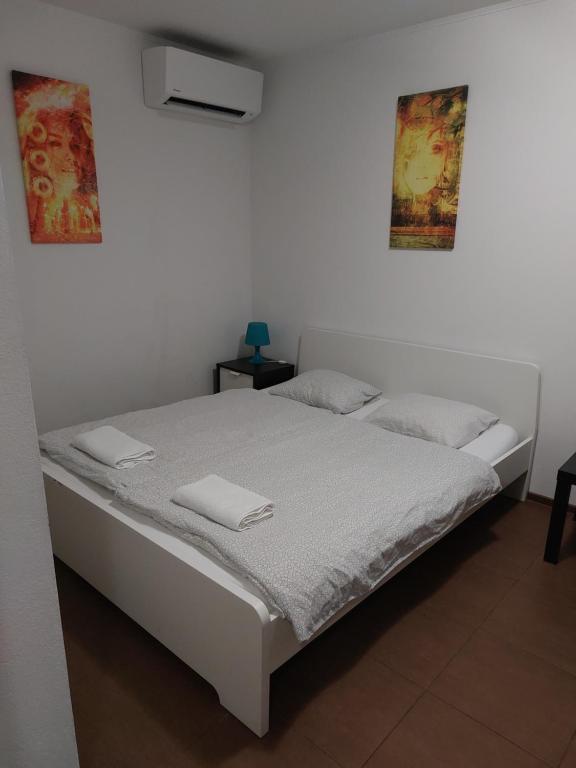 a white bedroom with a bed with white sheets at Apartmán - súkromie v meste (12) in Bratislava
