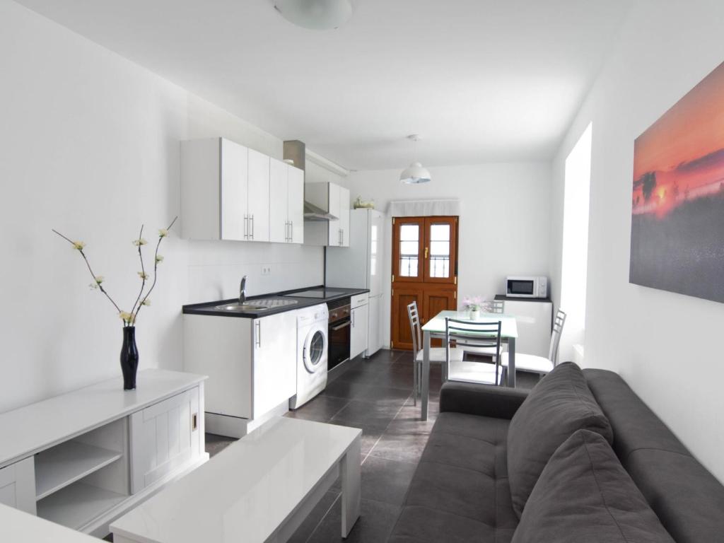 a kitchen and living room with a couch and a table at Precioso apartamento para 4 en Liencres in Liencres