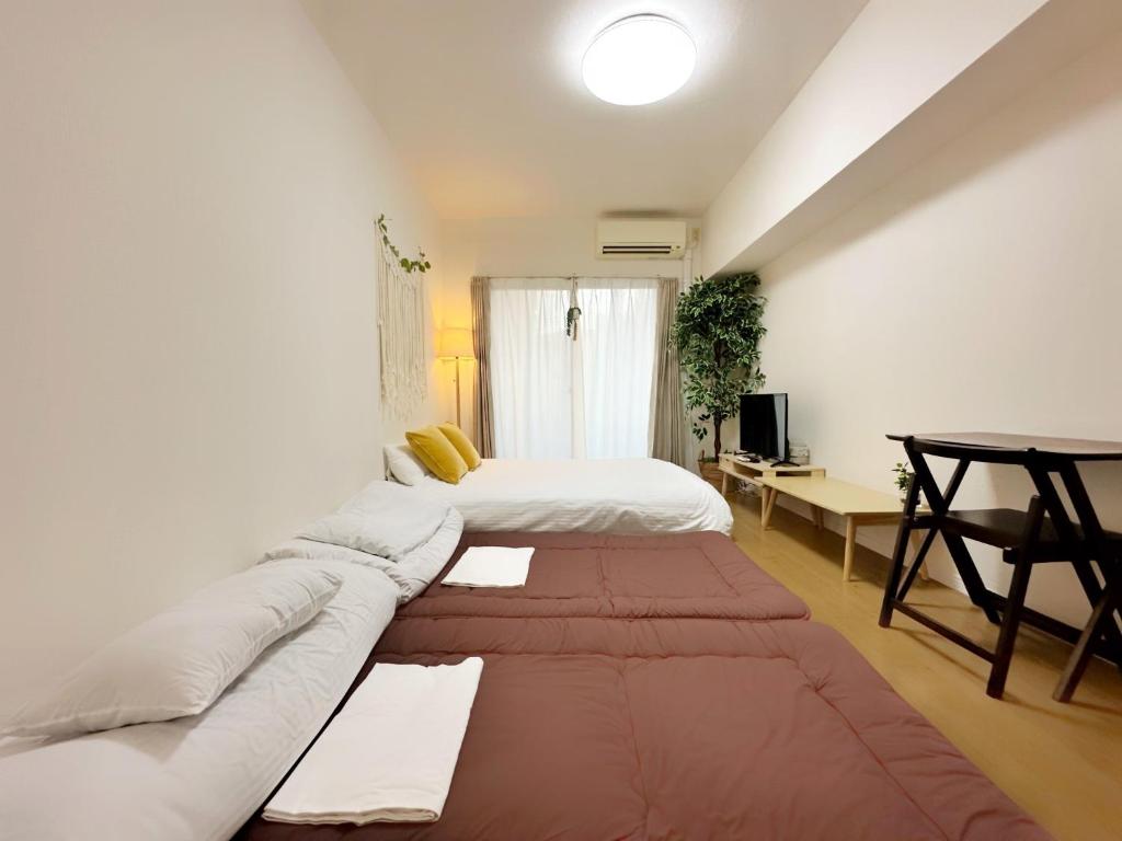 a room with a couch and a bed and a desk at Picoro Hakata - Vacation STAY 11328 in Fukuoka