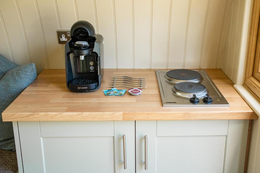 a kitchen counter with a coffee maker and a stove at Glamping at South Lytchett Manor in Poole