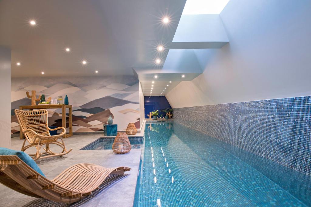 a swimming pool with chaise lounges and a swimming pool at Hotel Parister & Spa in Paris
