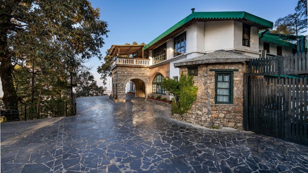 a house with a stone driveway in front of it at Rokeby Manor in Mussoorie