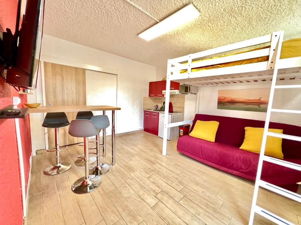 Habitación pequeña con litera, mesa y sillas en ~ Le riad ~ Studio 1/4 Pers, porte du Futuroscope, en Chasseneuil-du-Poitou