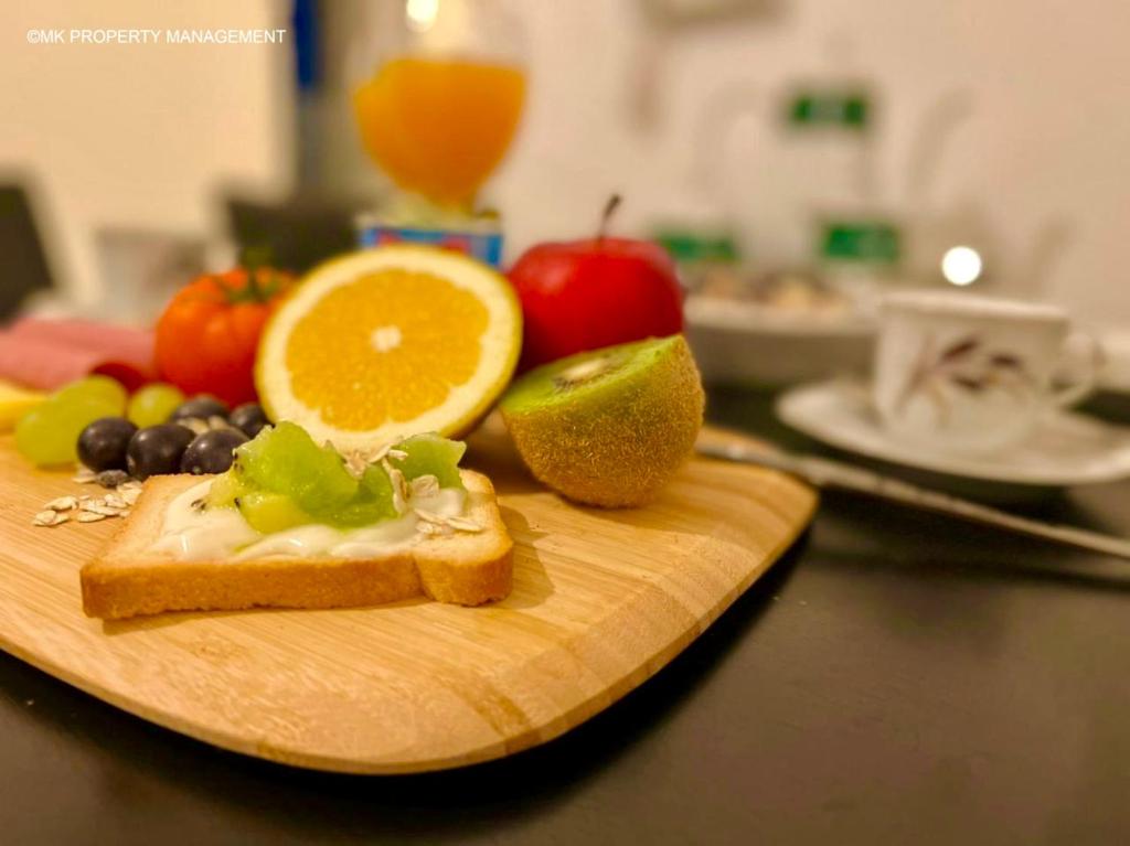 a cutting board with bread and fruit on a table at City Flats Apt.C307 in Larnaca