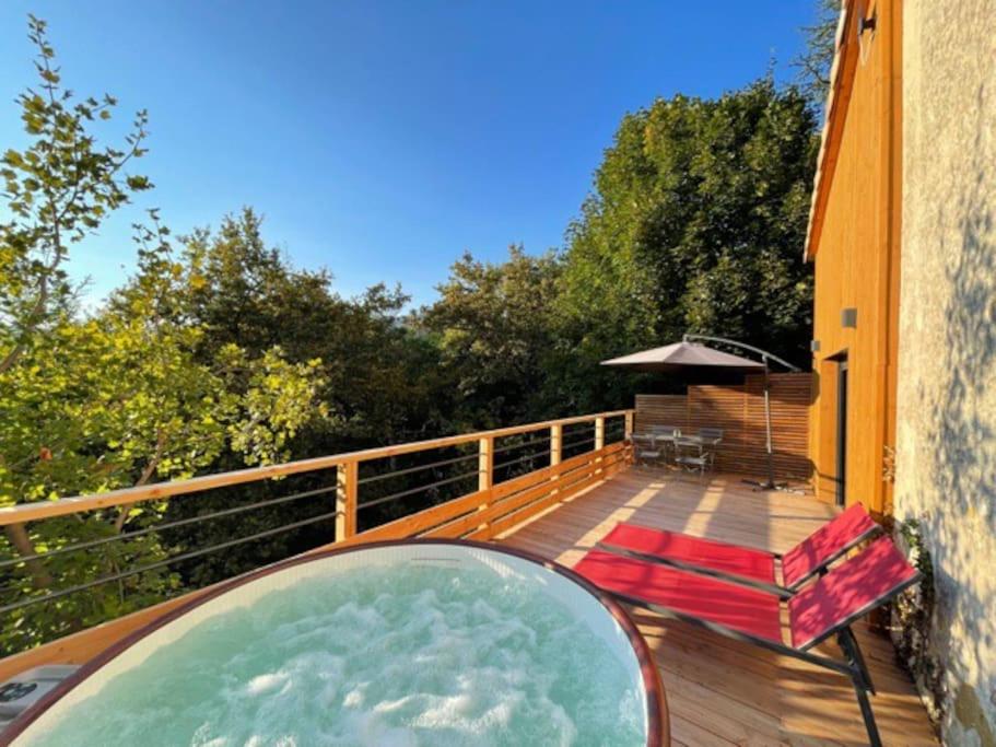 戴內尼費的住宿－Maisonnette en pleine nature, spa, village à pieds，房屋甲板上的热水浴池