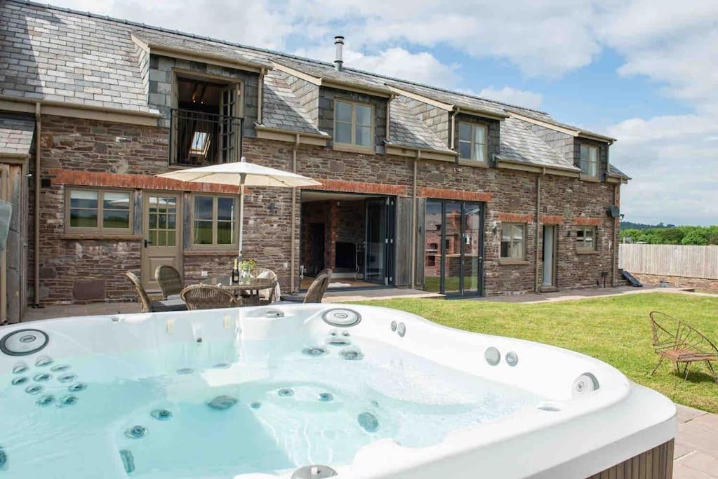 a hot tub in the yard of a house at Coed farm-hot tub-sleeps 12-near Brecon in Brecon