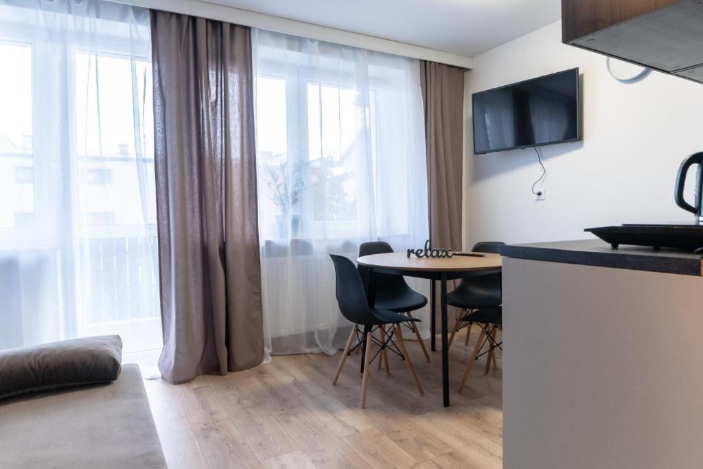拉多姆的住宿－Komfortowe przytulne nowoczesne mieszkanie Radom，厨房以及带桌椅的起居室。