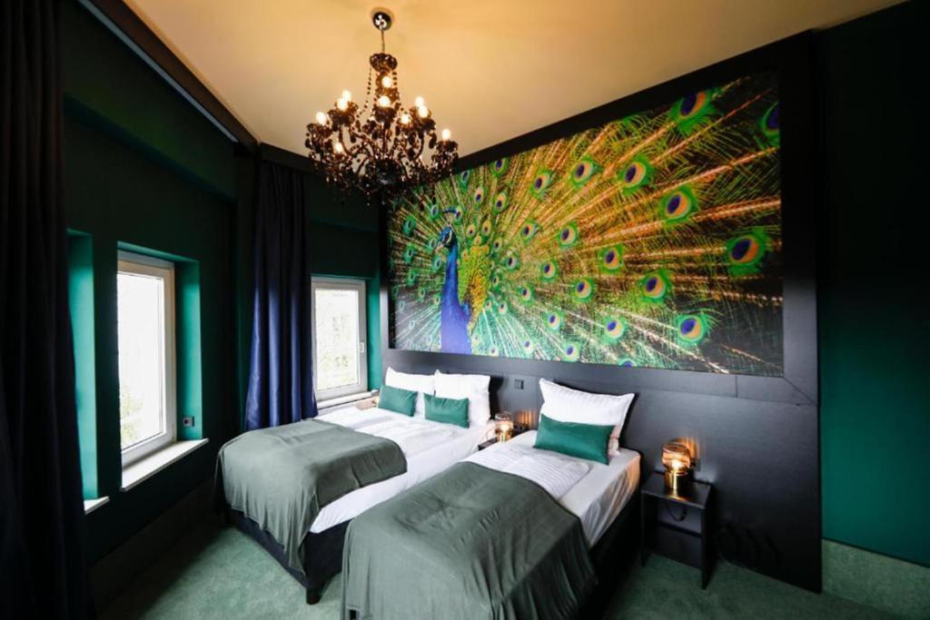 a bedroom with two beds with a peacock painting on the wall at Sleephotels Casino in Hamburg