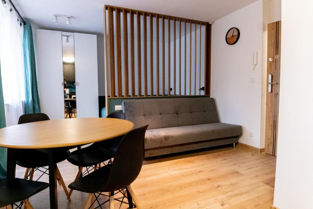 a living room with a table and a couch at Komfortowe przytulne nowoczesne mieszkanie Radom in Radom