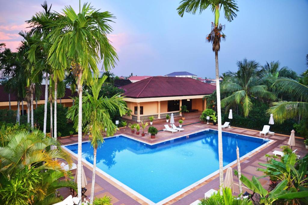 an aerial view of a resort swimming pool with palm trees at Angkor Hotel in Siem Reap