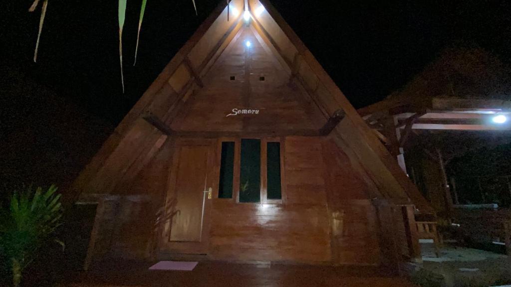 - une porte d'entrée en bois d'une maison la nuit dans l'établissement Sandhya Giri Beach Resort, à Brono