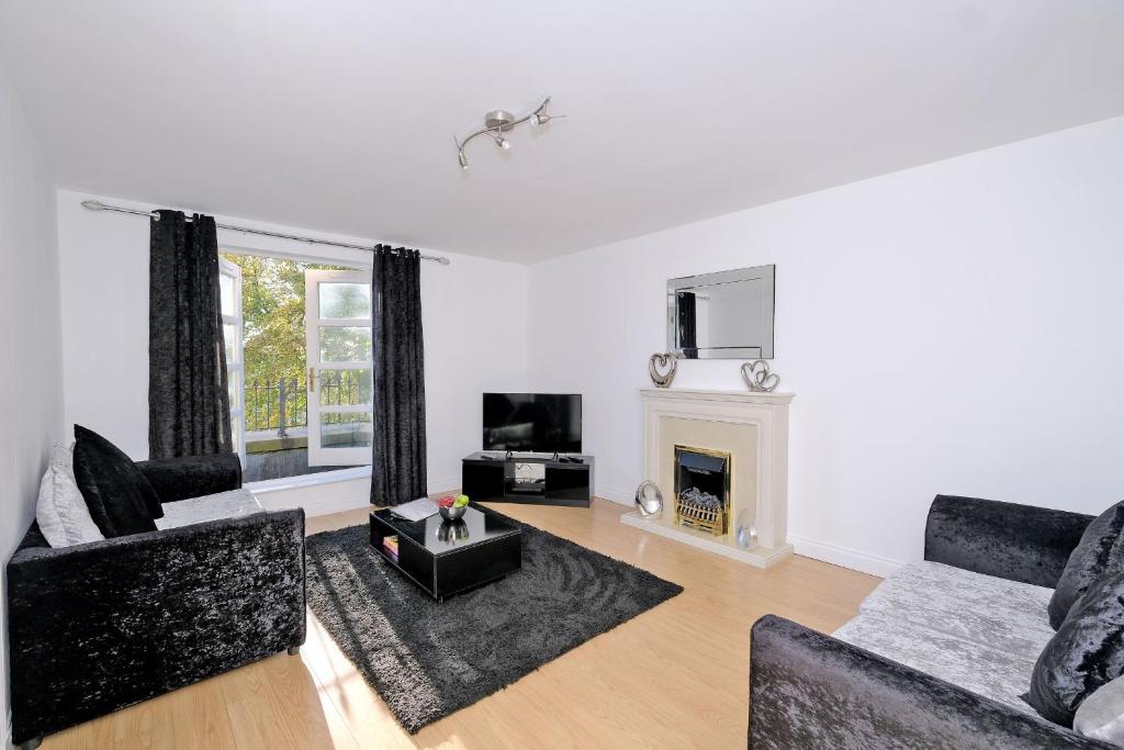 ein Wohnzimmer mit 2 Sofas und einem Kamin in der Unterkunft Orange Apartments Beechgrove Gardens in Aberdeen