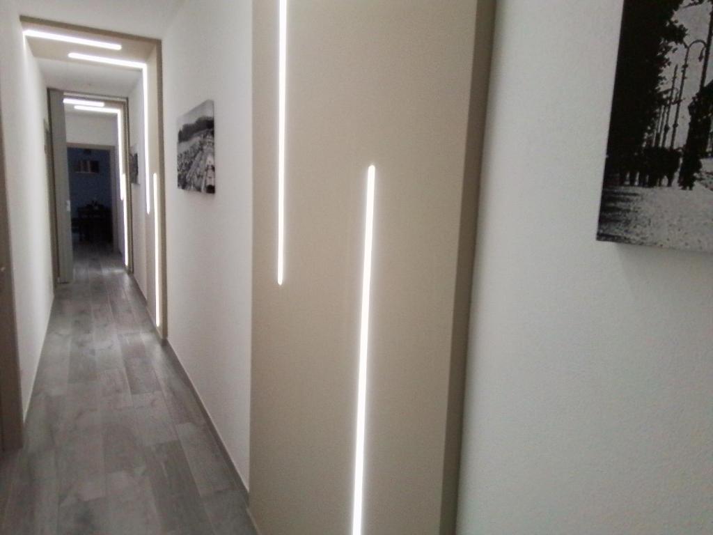 a hallway with white walls and a hallway with paintings at DELEDDA HOME in Cagliari