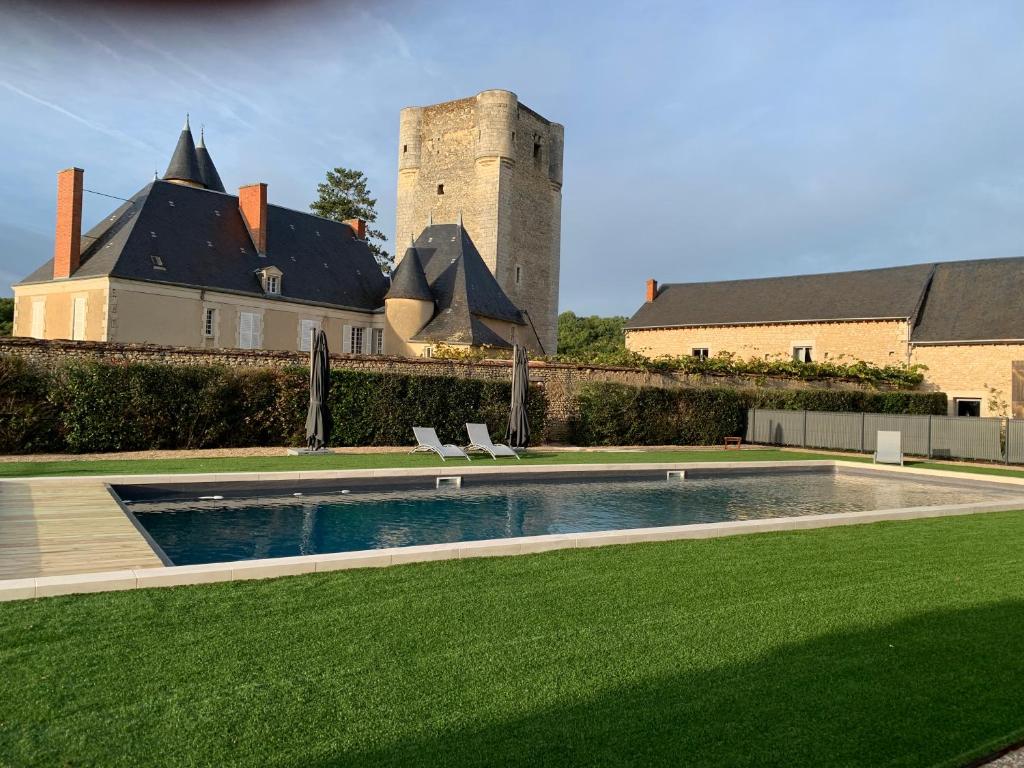 uma piscina em frente a um edifício com um castelo em Château de Mazières em Tendu