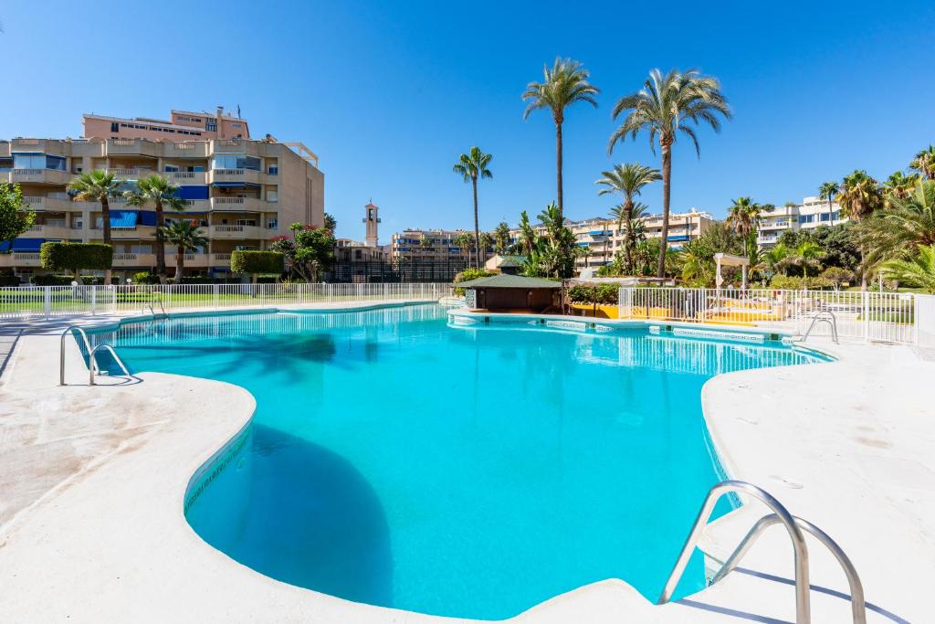 een zwembad op een resort met palmbomen bij Costa Lago Playa in Torremolinos