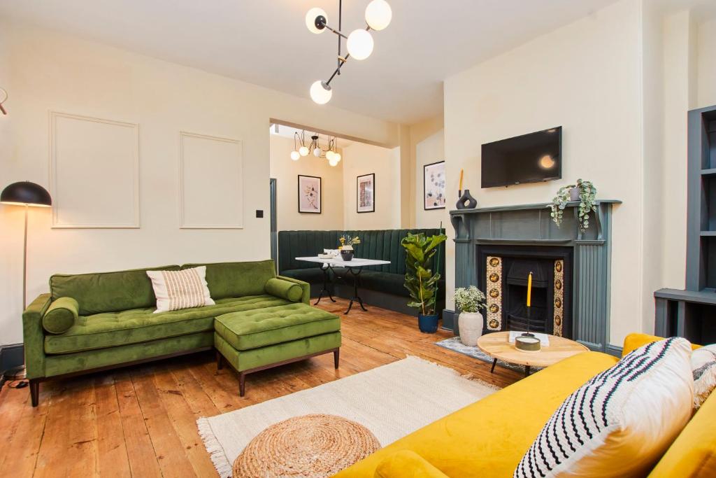 ein Wohnzimmer mit einer grünen Couch und einem Kamin in der Unterkunft No2 St Peters Street in Winchester