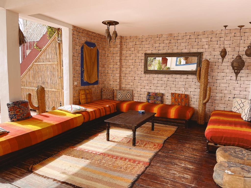 una sala de estar con un sofá y una mesa en La Paix Hôtel , Restaurant, en Taghazout