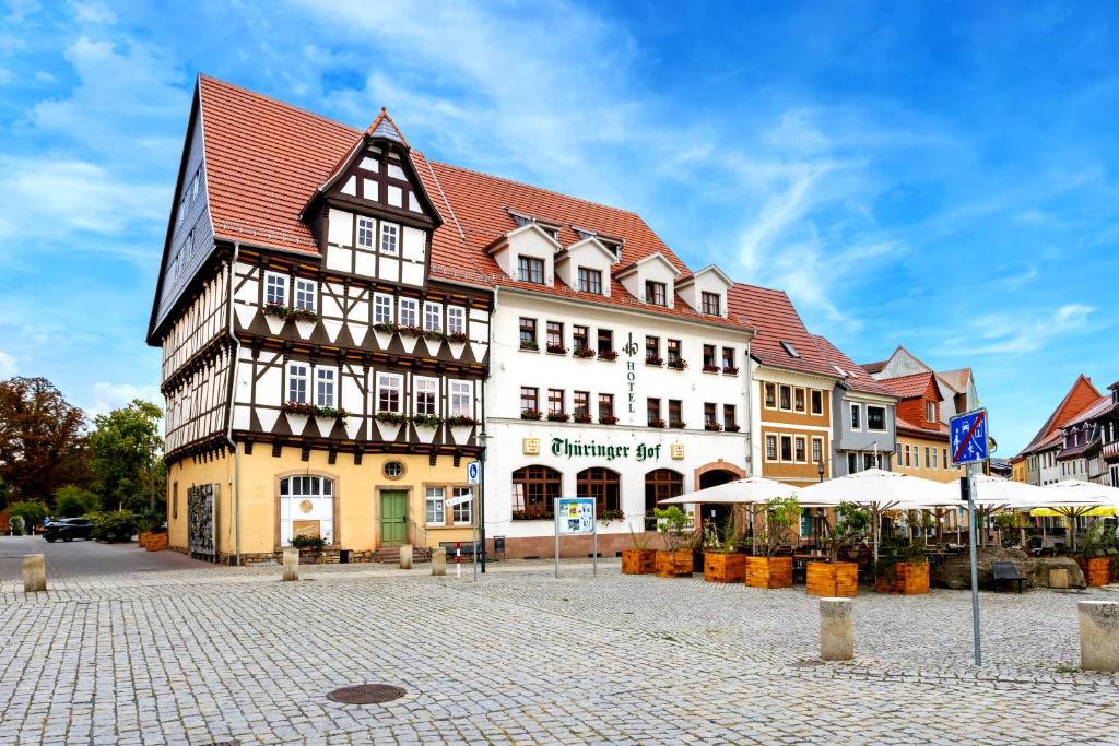 ein großes Gebäude mit rotem Dach auf einem Stadtplatz in der Unterkunft Hotel-Restaurant Thüringer Hof in Bad Frankenhausen