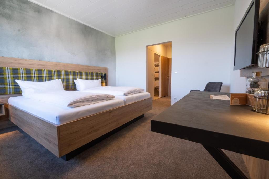 1 dormitorio con cama, escritorio y mesa en Landgasthof Adler, en Utzmemmingen