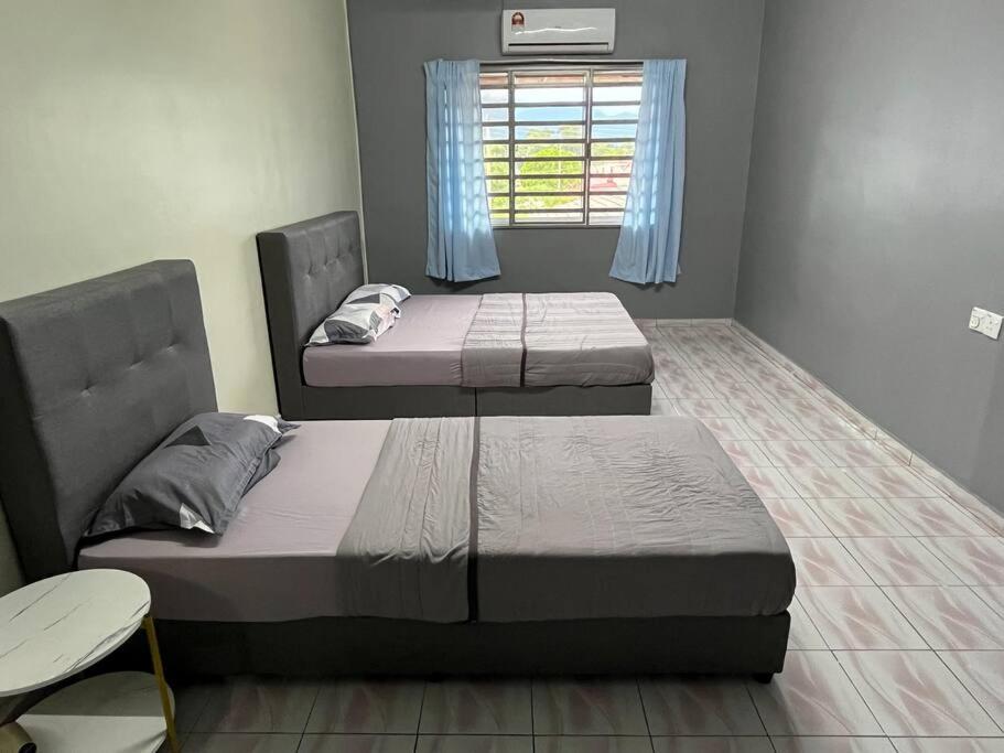 2 camas en una habitación con ventana en Homestay Malim Nawar, en Malim Nawar