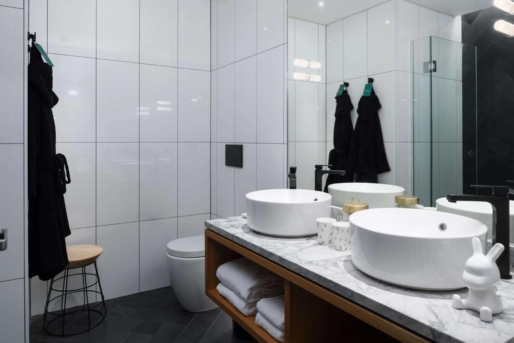 a bathroom with two sinks and a mirror at QT Wellington in Wellington