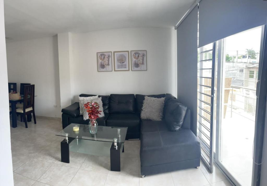 a living room with a blue couch and a glass table at Apartamento amoblado in Sincelejo