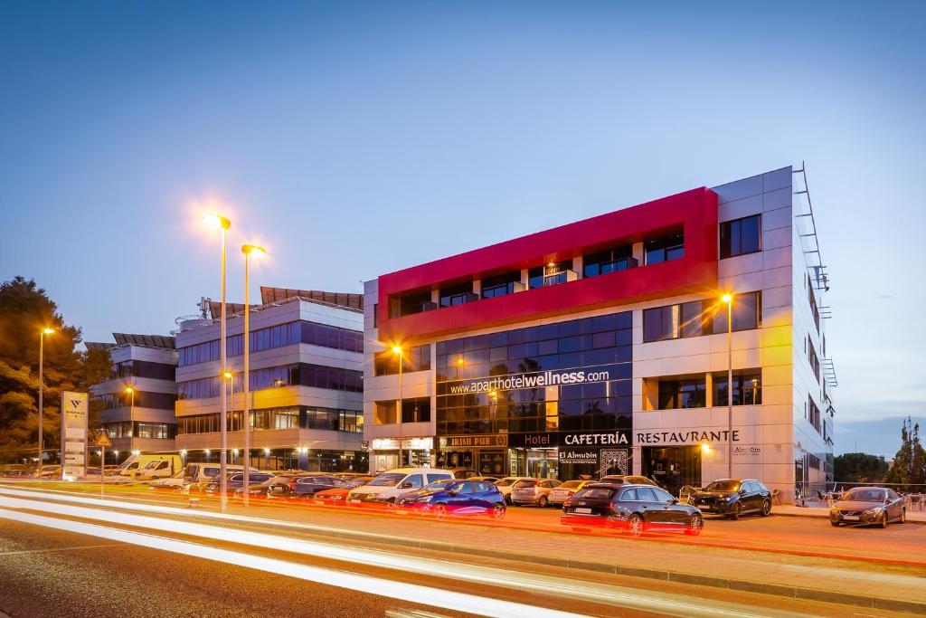 un edificio con auto parcheggiate di fronte ad esso in una strada di Aparthotel Wellness a Paterna