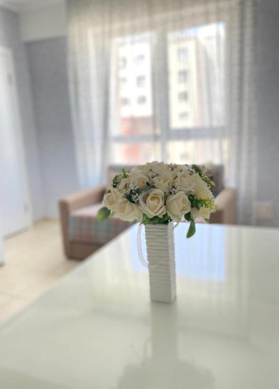 a vase filled with white flowers sitting on a table at Luxury apartment in Chişinău