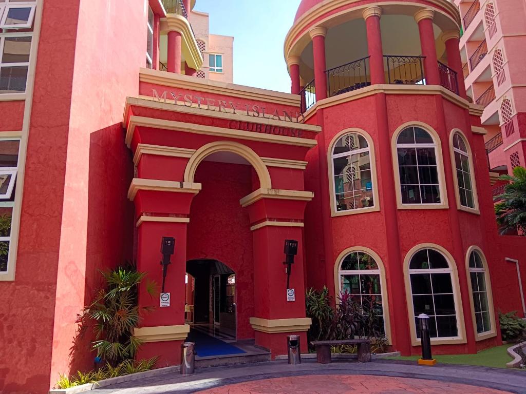 a red building with an arch in front of it at Seven Seas Condo Resort Beautiful Location in Jomtien Beach