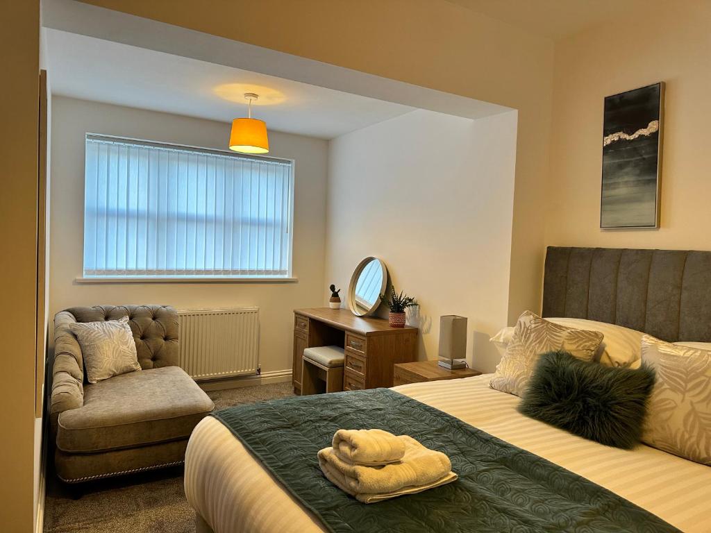 - une chambre avec un lit, une chaise et un miroir dans l'établissement Belsay 4 bedroom bungalow with loft conversion, à Horden