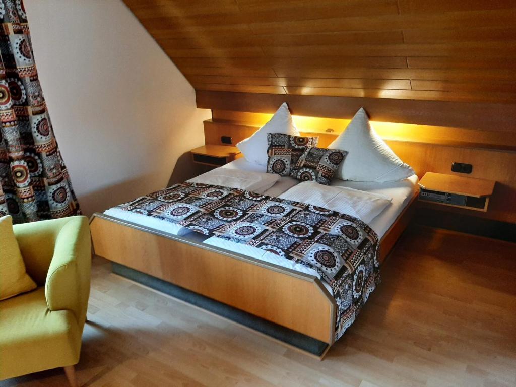 1 dormitorio con 1 cama grande y 1 silla en Gasthof Hirsch, en Schollbrunn