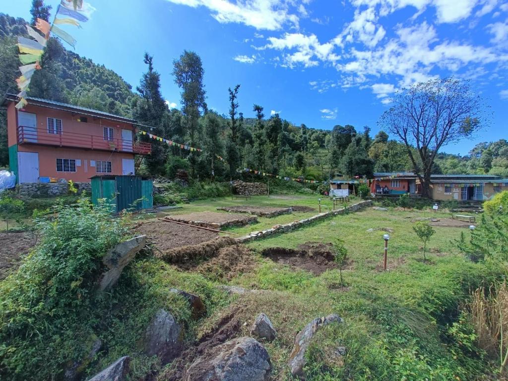 a village in the mountains with a house at Chopta Eco Cottage & Camping in Sari