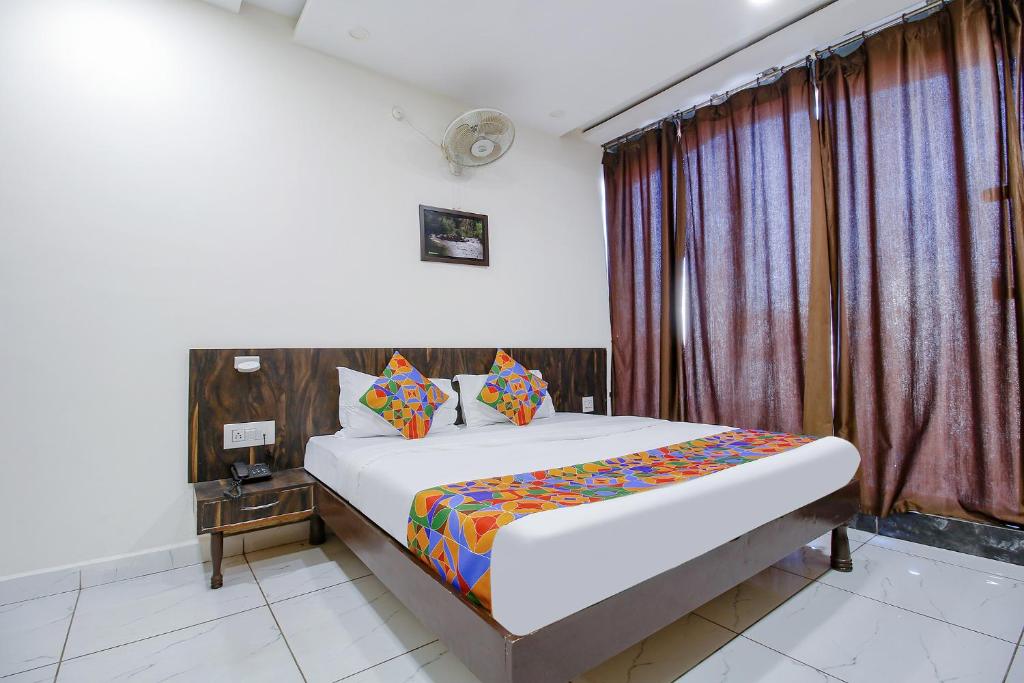 a bedroom with a bed and a window at FabHotel HTC in Bhopal