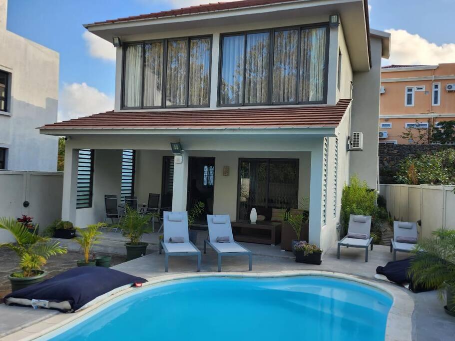 a house with a swimming pool in front of a house at luxury cheerful 4 bedrooms villa in Calodyne in Calodyne